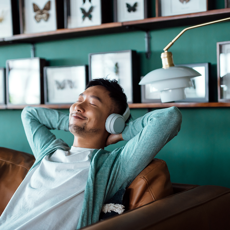 Ihminen kuuntelee kuulokkeilla